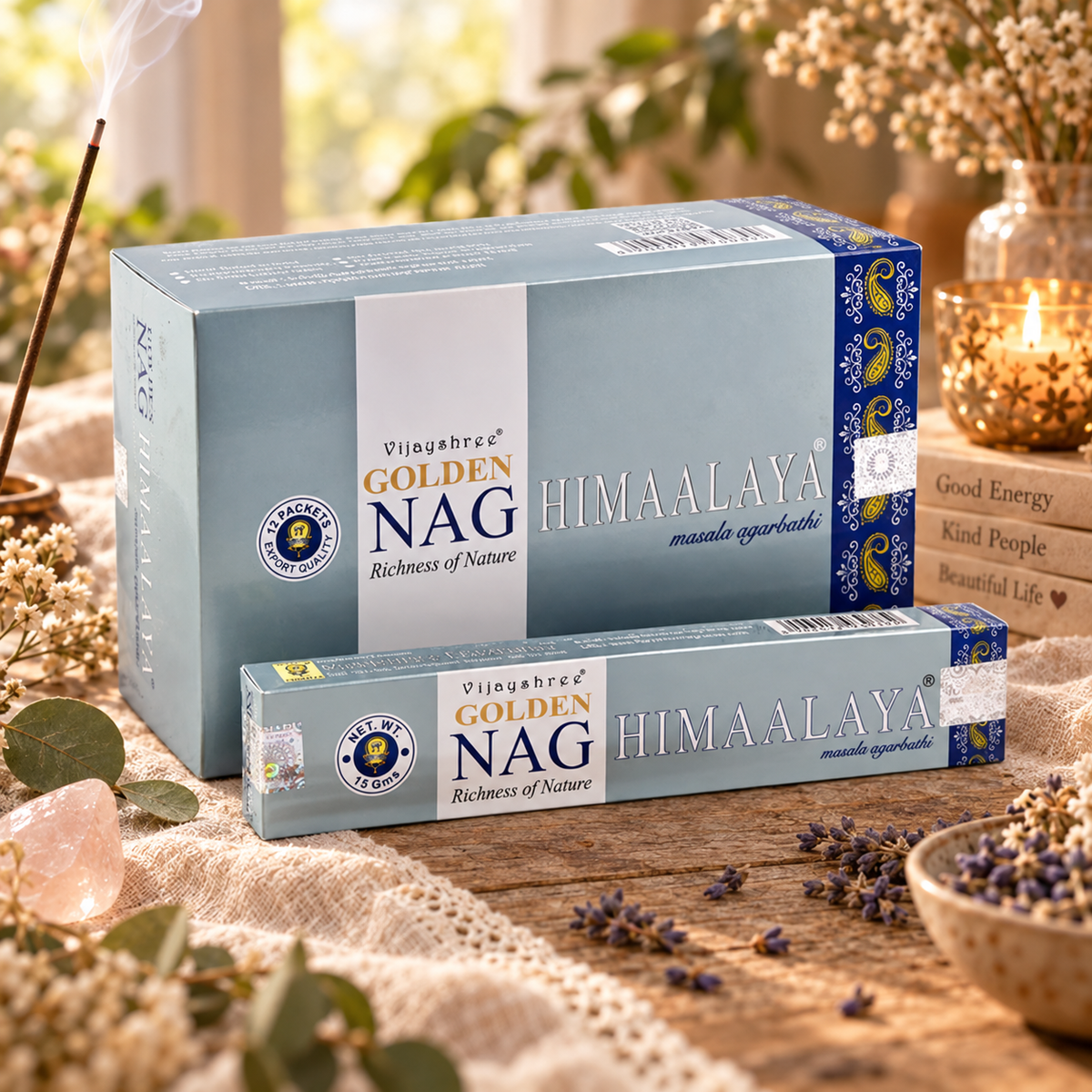 Confezioni grigio azzurro di incenso Golden Nag Himalaya, su un tavolo con fiori secchi.