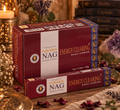 Confezioni bordeaux di incenso Golden Nag Energy Clearing, accanto a fiori secchi e ametista.