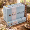 Confezioni azzurro chiaro di incenso Golden Nag White Oudh, su un tavolo con fiori e lavanda.