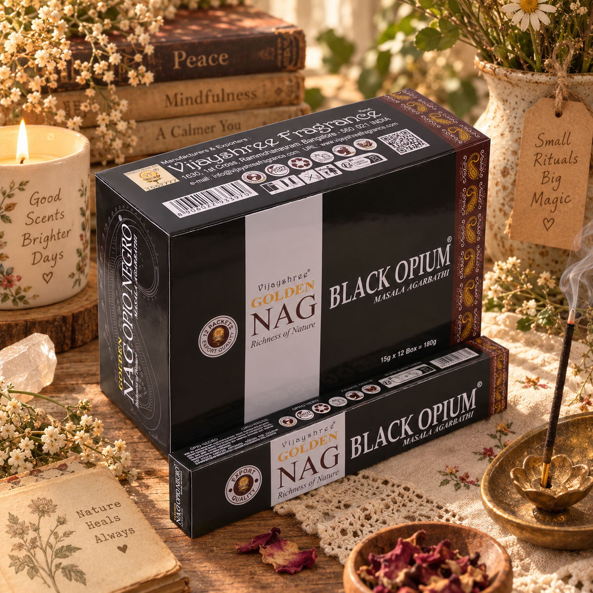 Confezioni nere di incenso Golden Nag Black Opium, accanto a un bastoncino acceso.